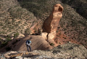 J rappelling off the canyon rim with Sentinel Spire behind